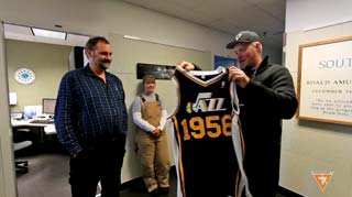 Utah Jazz owner Greg Miller presents Bill Coughran with a unique Utah Jazz jersey