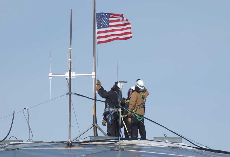 lowering the flag atop the dome