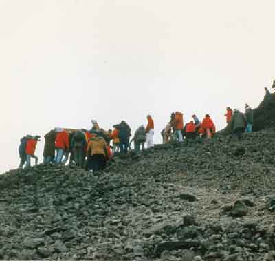 a crowd of folks follow the cross carriers